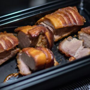Imagem de costelinhas de porco crocantes e douradas sendo cozidas em uma Airfryer. A carne é suculenta e tenra, com uma crosta crocante por fora. A Airfryer está em uma superfície de cozinha com ingredientes como sal, pimenta e ervas ao redor.