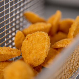 Imagem de couve-flor crocante cozida na airfryer, disposta em uma tigela branca. Os floretes de couve-flor são dourados e crocantes, com algumas bordas levemente queimadas. A couve-flor é polvilhada com sal e pimenta e decorada com uma pitada de salsa fresca.