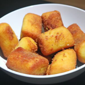Imagem de coxas e sobrecoxas de frango douradas e crocantes cozidas em uma airfryer.