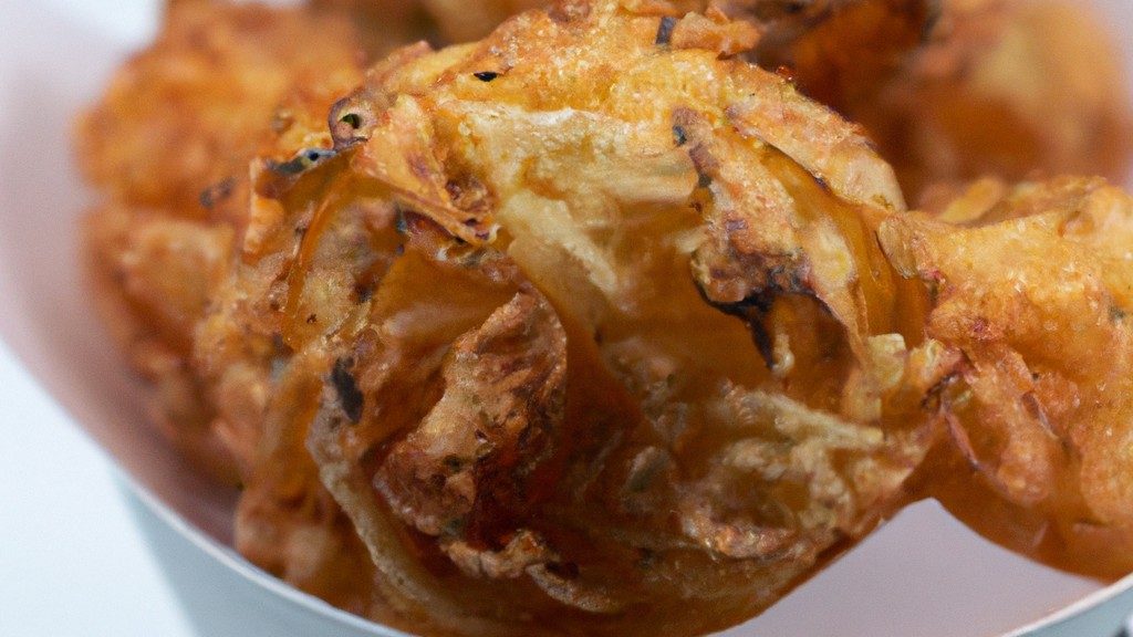 Imagem de crispy de repolho cozido na airfryer. O repolho é cortado em pedaços e empanado com farinha, ovo e pão ralado. O repolho é cozido na airfryer até ficar dourado e crocante.