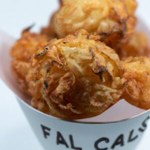 Imagem de crispy de repolho cozido na airfryer. O repolho é cortado em pedaços e empanado com farinha, ovo e pão ralado. O repolho é cozido na airfryer até ficar dourado e crocante.