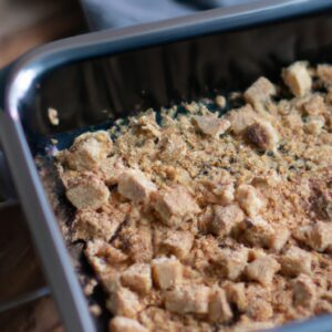 Foto de crumble de banana em ramequins na Airfryer. A cobertura crocante de paçoca é dourada e crocante, contrastando com o recheio de banana macia e caramelizada. O fundo da Airfryer é visível, indicando que o crumble foi cozido neste aparelho.