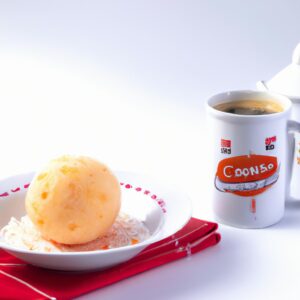 Imagem de uma caneca de cuscuz preparado na Airfryer, com uma garfo espetando um pedaço e uma colher ao lado. O cuscuz é dourado e fofo, com grãos bem definidos.