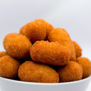 Imagem de um prato de Drumet de frango crocante cozido em uma Airfryer, acompanhado de batatas fritas e molho.