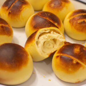 Imagem de enroladinhos de pão de forma fritos crocantes em uma airfryer. Os enroladinhos são recheados com queijo e presunto e polvilhados com sementes de gergelim.