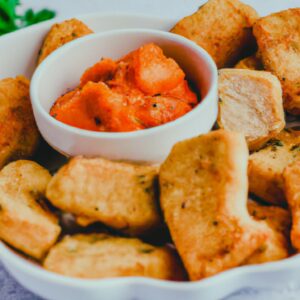 Imagem de uma farofa crocante e dourada feita na airfryer, com pedaços de cebola e bacon crocantes.