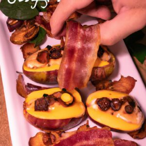 Imagem de um prato de figo recheado com queijo e bacon, preparado na Airfryer. Os figos estão dourados e crocantes por fora, com o queijo derretido e o bacon crocante por dentro. O fundo é branco e o prato é guarnecido com folhas de hortelã.