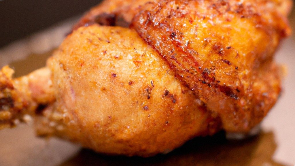 Imagem mostrando um filé de frango recheado com queijo e presunto, empanado e cozido em uma Airfryer. O frango está dourado e crocante, com o queijo e o presunto derretidos e visíveis no interior.