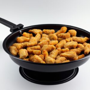 Imagem de um filé de panga empanado dourado e crocante, cozido em uma airfryer. O peixe é servido em um prato com fatias de limão e um molho tártaro à parte.