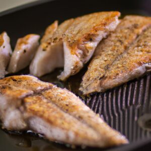 Imagem de um filé de tilápia assado em uma airfryer. O filé é coberto com uma crosta crocante e fica sobre uma cama de vegetais. O texto "Filé De Tilápia Assado Na Airfryer: Pronto Em 20 Minutos" aparece na parte superior da imagem.