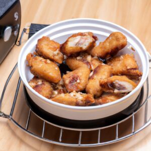 Imagem de frango frito crocante com molho shoyu, servido em um prato ao lado de arroz e vegetais. O frango é dourado e tem uma pele crocante, e o molho é espesso e escuro.