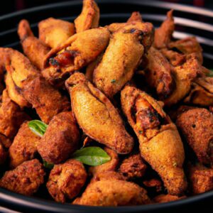 Uma imagem de um prato de Frango Indiano Na Airfryer, coberto com especiarias e ervas. O frango é dourado e crocante, e está rodeado por vegetais coloridos, como pimentos, cebolas e tomates.