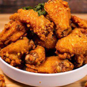 Imagem de frango dourado e crocante cozido em uma Airfryer. O frango é temperado com ervas e especiarias e tem uma pele crocante e suculenta.