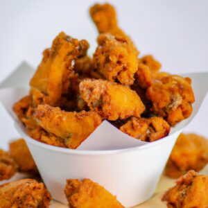Frango frito crocante com pele dourada em uma Airfryer. O frango é cozido em um molho cremoso de cogumelos, cenoura e cebola, coberto com uma camada de queijo derretido.