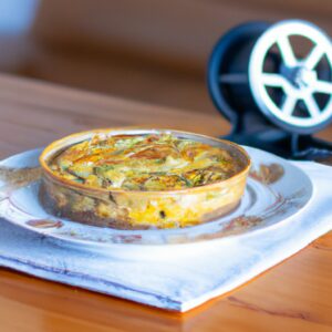 Imagem de uma frittata cozida em uma Air Fryer, apresentando uma superfície dourada e ingredientes coloridos como ovos, queijo e vegetais. Esta imagem retrata uma refeição saborosa e conveniente, perfeita para um café da manhã ou almoço fácil e rápido.