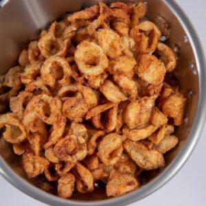 Imagem de uma tigela cheia de grãos crocantes cozidos na Airfryer. Os grãos são dourados e crocantes, com uma textura leve e arejada. Eles são perfeitos para um lanche saudável ou como acompanhamento de uma refeição.