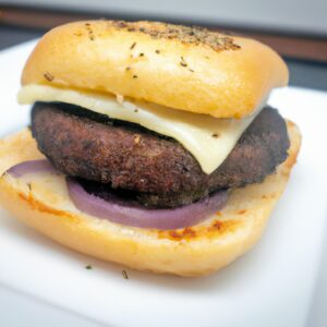 Imagem de um hambúrguer de grão de bico redondo e dourado cozido em uma airfryer. O hambúrguer é guarnecido com alface, tomate, cebola e um pãozinho.