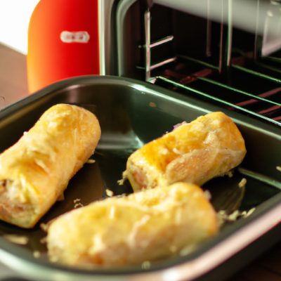 Imagem de rolinhos primavera crocantes e dourados cozidos em uma Airfryer. Os rolinhos são colocados em uma cesta de arame para fritura com ar quente, que circula ao redor deles, resultando em um exterior crocante e um interior cozido uniformemente.