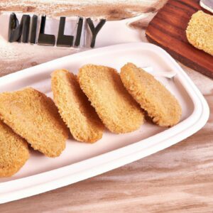 Imagem de uma porção de jilós empanados e fritos em uma air fryer, servidos em um prato com fatias de limão.