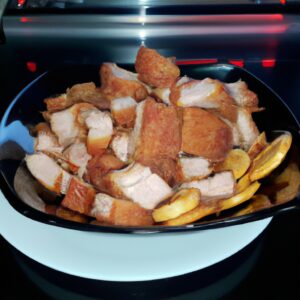 Imagem de Joelhos de Porco crocantes e dourados cozidos em uma Airfryer. A imagem mostra o prato em um prato, acompanhado de vegetais grelhados.