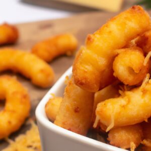 Imagem de um prato de macarrão com queijo feito na Airfryer, com uma crosta dourada e borbulhante.