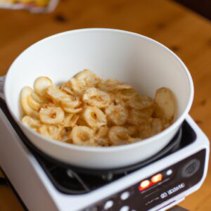 Imagem mostra um prato de macarrão cremoso cozido em uma Airfryer, ao lado de ingredientes como leite, creme de leite, queijo parmesão e macarrão.