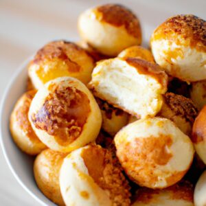 Imagem de uma maminha suculenta e dourada, cozida na Airfryer. A carne está coberta com uma manteiga derretida e temperada, e está servida em um prato com rodelas de limão.