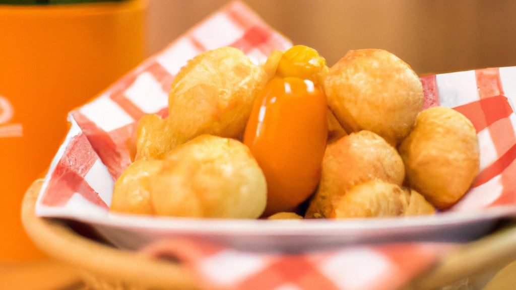 Imagem de mandioquinhas cortadas em rodelas e colocadas na cesta da Airfryer. O fundo é branco e o texto 