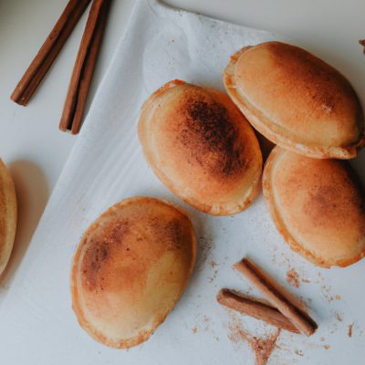 Imagem de uma massa de pastel frita na airfryer, polvilhada com açúcar e canela. A massa está dourada e crocante, e o açúcar e a canela criam uma cobertura doce e aromática.