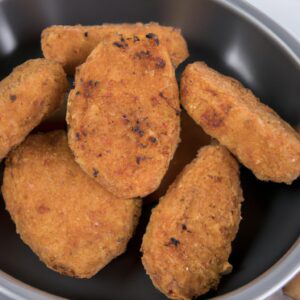 Imagem de um medalhão de alcatra dourado e crocante cozido em uma Airfryer, servido em um prato com uma guarnição de vegetais grelhados. O medalhão é suculento e macio por dentro, com uma crosta crocante e dourada por fora.
