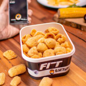 Fotografia de milho doce torrado em uma airfryer. Os grãos são dourados e crocantes, com uma pitada de sal. A airfryer fica ao fundo, com a cesta removida para revelar o milho.