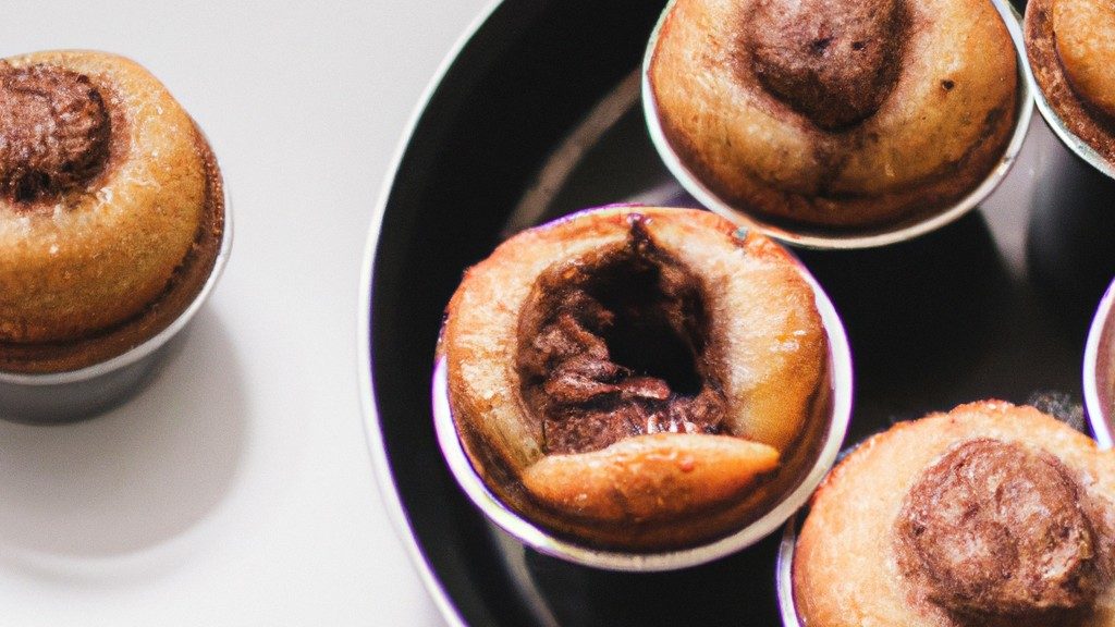 Imagem de muffins de Nutella assados na Airfryer, com gotas de Nutella derretida por cima. Esses muffins são fofos, dourados por fora e derretem na boca.