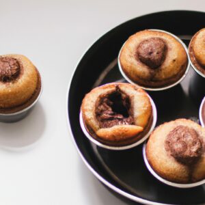 Imagem de muffins de Nutella assados na Airfryer, com gotas de Nutella derretida por cima. Esses muffins são fofos, dourados por fora e derretem na boca.