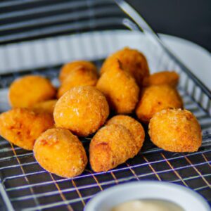Imagem mostrando uma variedade de alimentos preparados na airfryer, incluindo frango, peixe, batatas fritas e legumes. Esses alimentos são uma ótima opção de almoço, pois são fáceis de preparar e ficam crocantes e deliciosos na airfryer.