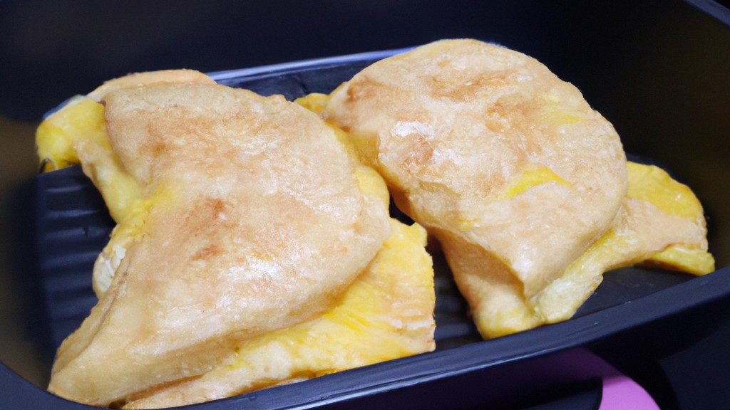 Imagem de um omelete com queijo branco feito na Airfryer, mostrando sua superfície dourada e fofa, com um recheio cremoso de queijo branco derretido.