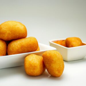 Imagem de pepitas de ouro branco crocantes e douradas cozidas em uma Airfryer, prontas para serem servidas.
