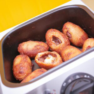 Imagem de uma cesta de airfryer cheia de ovos de codorna cozidos. Os ovos são dourados e crocantes, com alguns pontos escuros carbonizados. Eles estão dispostos em uma única camada na cesta, com um pouco de espaço entre eles.