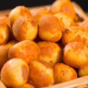 Imagem de uma cesta de Panados Airfryer de 10 polegadas cheia de panados dourados e crocantes. Os panados são servidos em um prato branco com um lado de molho para mergulhar.