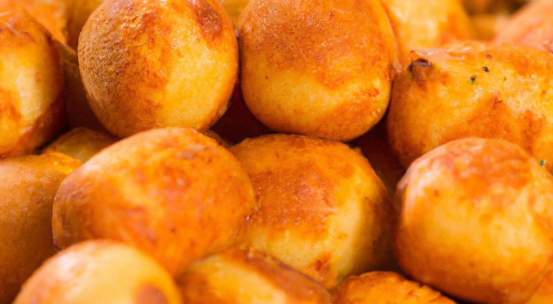 Imagem de uma cesta de Panados Airfryer de 10 polegadas cheia de panados dourados e crocantes. Os panados são servidos em um prato branco com um lado de molho para mergulhar.