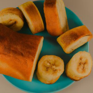 Imagem de pão de banana e canela cozido em uma airfryer. O pão tem uma crosta marrom-dourada e é polvilhado com canela. O pão é cortado ao meio e cozido em uma cesta de airfryer.