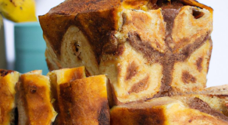Imagem de um pão de banana dourado e crocante cozido em uma Airfryer, apresentado em uma tigela branca com fatias cortadas ao lado. O pão é polvilhado com nozes picadas e tem uma crosta crocante com um interior macio e úmido.