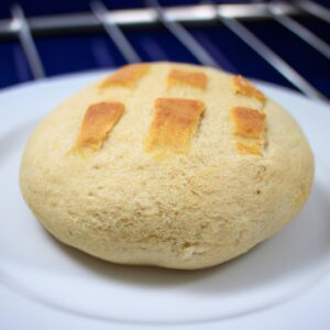 Imagem de fatias de pão de forma torradas na airfryer com manteiga derretida por cima. O pão está dourado e crocante, com a manteiga espalhada uniformemente. O fundo é uma superfície escura, possivelmente uma mesa ou bancada.