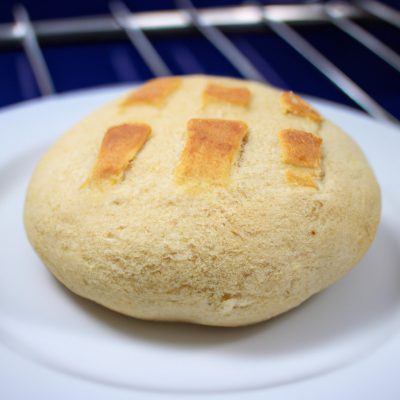 Imagem de fatias de pão de forma torradas na airfryer com manteiga derretida por cima. O pão está dourado e crocante, com a manteiga espalhada uniformemente. O fundo é uma superfície escura, possivelmente uma mesa ou bancada.