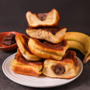 Imagem de uma airfryer com uma fatia de pão de forma torrada, coberta com uma camada de Nutella e fatias de banana. O pão está dourado e crocante, enquanto a Nutella e a banana estão derretidas e borbulhantes.