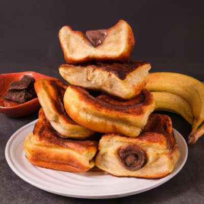 Imagem de uma airfryer com uma fatia de pão de forma torrada, coberta com uma camada de Nutella e fatias de banana. O pão está dourado e crocante, enquanto a Nutella e a banana estão derretidas e borbulhantes.
