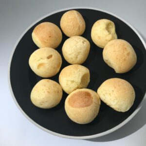 Imagem de pão de queijo assado em uma fritadeira de ar, com crosta dourada e centro macio e aerado. O forno de minas é um tipo tradicional de pão de queijo brasileiro, conhecido por sua textura crocante por fora e macia por dentro.