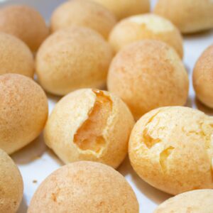 Imagem de pão de queijo recheado com catupiry feito na Airfryer. Os pães de queijo são dourados e crocantes, com recheio cremoso de catupiry escorrendo.