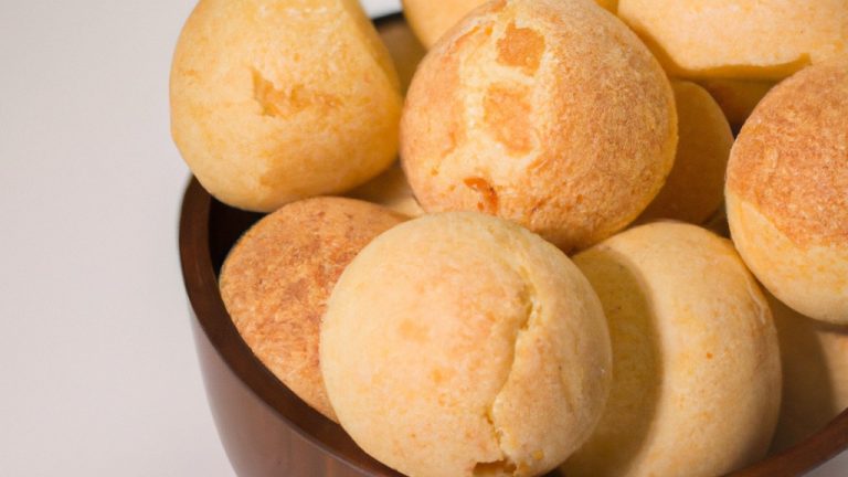 Imagem de um pão de queijo redondo e dourado, feito na Airfryer. O pão de queijo é coberto com queijo derretido e tem uma textura crocante.