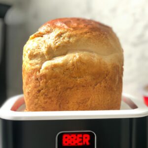 Imagem de uma torrada crocante feita na Airfryer, coberta com manteiga derretida e uma pitada de sal. O fundo desfocado mostra uma Airfryer.