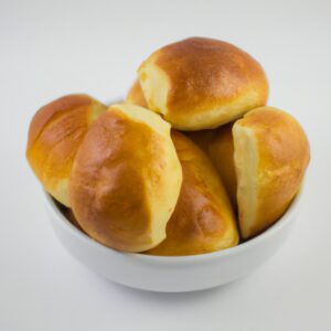 Imagem de um pãozinho dourado e crocante recém-saído da Airfryer. O pãozinho tem uma crosta crocante e um interior macio e fofo.